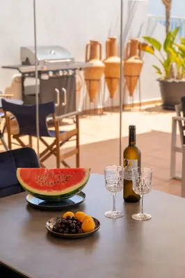 a table with a plate of fruit and a bottle of wine at Blue Penthouse Mackenzie in Larnaka