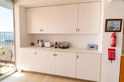 a kitchen with white cabinets and a counter at Blue Penthouse Mackenzie in Larnaka