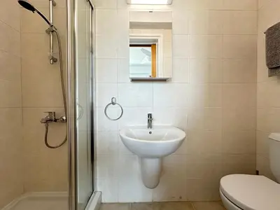 a bathroom with a sink and a shower and a toilet at Blue Penthouse Mackenzie in Larnaka