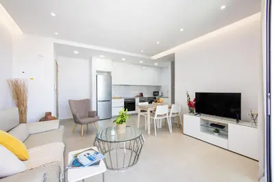 a living room with a couch and a tv and a table at Attika Residence in Strovolos