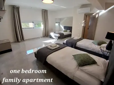 a bedroom with three beds and a family apartment at Georgiana Suites in Larnaka