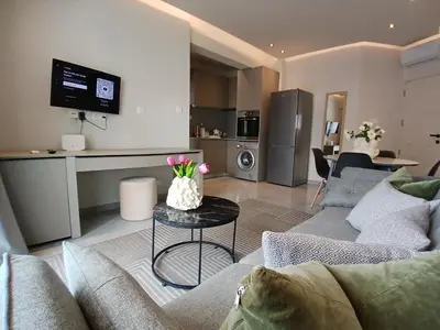a living room with a couch and a table with flowers on it at Georgiana Suites in Larnaka