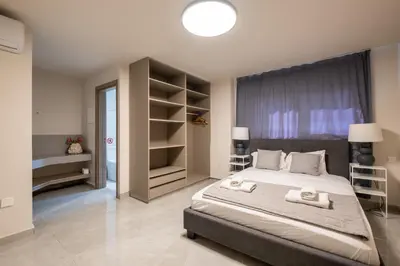 a bedroom with a large bed with two towels at Georgiana Suites in Larnaka
