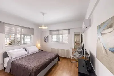 a bedroom with a bed and a flat screen tv at Luxurious Bright & Stylish 2BR with Office in Nicosia in Nicosia