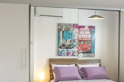 a bedroom with purple pillows and a painting on the wall at Luxurious Bright & Stylish 2BR with Office in Nicosia in Nicosia