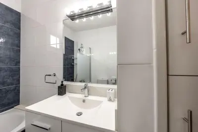 a white bathroom with a sink and a mirror at Luxurious Bright & Stylish 2BR with Office in Nicosia in Nicosia