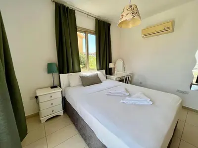 a bedroom with a large white bed with a window at Eliza Suite at Pernera Beach in Protaras