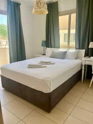 a large bed with two towels on top of it at Eliza Suite at Pernera Beach in Protaras