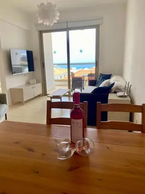 a bottle of wine and glasses sitting on a table at Aphrodite Sea View Suite in Protaras