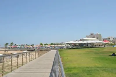 a boardwalk leading to a beach with a pier at Aphrodite Sea View Suite in Protaras