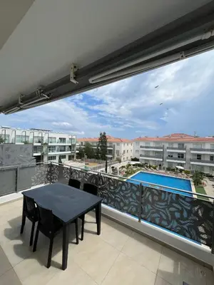 a balcony with a table and a swimming pool at Mythical Sands - Evexia in Paralimni