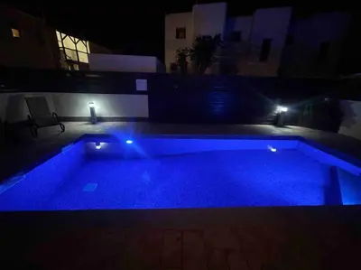 a large swimming pool at night with blue lights at 13 Crystal Lagoon Villa in Paralimni