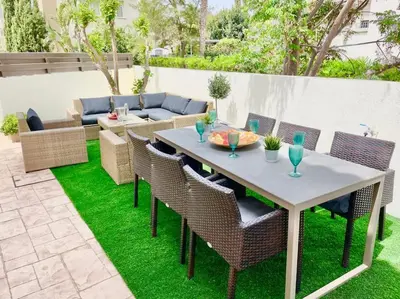 a patio with a table and chairs on grass at 13 Crystal Lagoon Villa in Paralimni