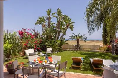 a patio with chairs and a table with food on it at Chelidonia Larnaca Seafront Villa in Meneou