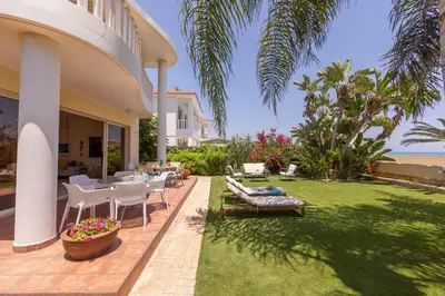 a patio with a table and chairs and the ocean at Chelidonia Larnaca Seafront Villa in Meneou