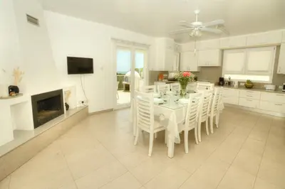 a white kitchen with a dining table and chairs at Villa Christina in Ayia Napa