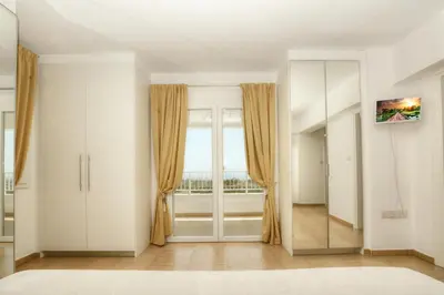 a room with white cabinets and a large window at Villa Christina in Ayia Napa