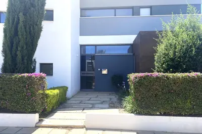 a building with a blue door and some bushes at NISSI PEARL Holiday Villas Ayia Napa in Ayia Napa