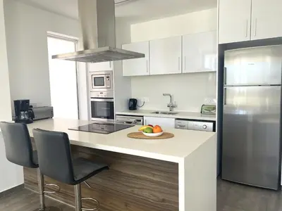 a kitchen with a counter with a bowl of fruit on it at NISSI PEARL Holiday Villas Ayia Napa in Ayia Napa