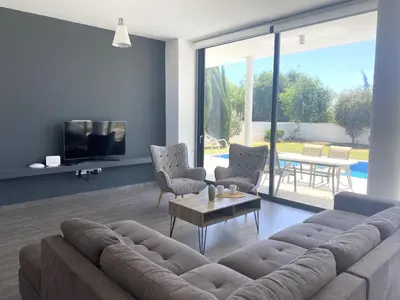 a living room with a large couch and a table at NISSI PEARL Holiday Villas Ayia Napa in Ayia Napa