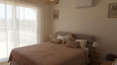 a bedroom with a bed with a large window at Nissi 3 Pool View 2 Bedroom Apartment with Large Veranda in Ayia Napa