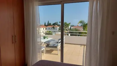 a bedroom with a view of a balcony at Nissi 3 Pool View 2 Bedroom Apartment with Large Veranda in Ayia Napa