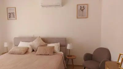 a bedroom with a bed with two pillows and a chair at Nissi 3 Pool View 2 Bedroom Apartment with Large Veranda in Ayia Napa