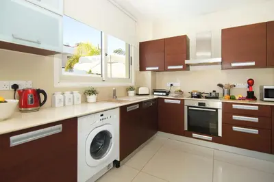 a kitchen with a washer and dryer in it at Villa Artemis - 30m from Pernera Beach in Protaras