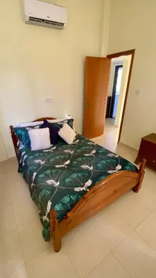 a bedroom with a bed with a green comforter at Villa Annalisarose in Ayia Napa