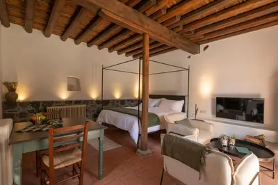 a bedroom with a bed and a table and chairs at Casa Oliva Guesthouse in Tris Elies