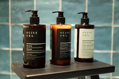 three bottles of hair products sitting on a shelf in a bathroom at Casa Oliva Guesthouse in Tris Elies
