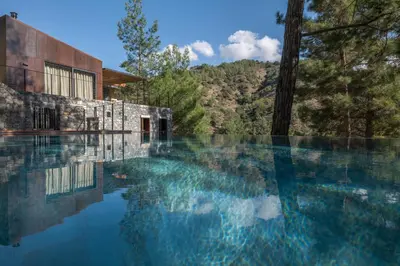 a pool of water in front of a building at Casa Oliva Guesthouse in Tris Elies