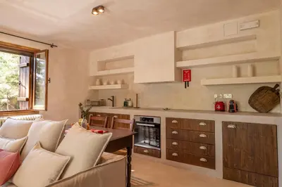 a kitchen with a table and chairs in a room at Casa Oliva Guesthouse in Tris Elies