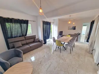 a living room with a couch and a table and chairs at Sunshine Villa Kapparis in Protaras