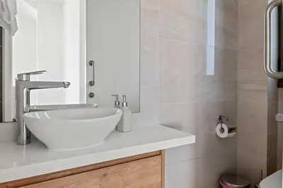 a bathroom with a white sink and a mirror at Serenity Waves Villa 12 in Sophtadhes