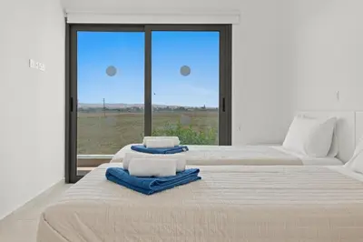 a bedroom with two beds with towels and a window at Serenity Waves Villa 10 in Sophtadhes