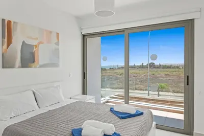 a bedroom with a bed and a large window at Serenity Waves Villa 16 in Larnaka