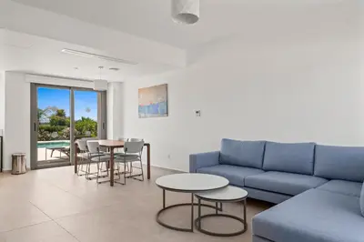 a living room with a couch and a table and chairs at Serenity Waves Villa 16 in Larnaka