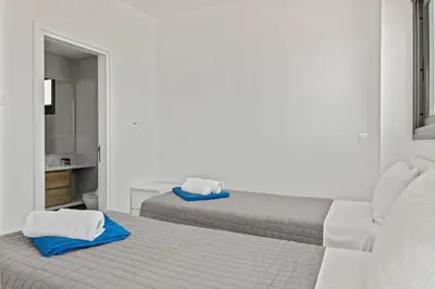 two beds in a white room with towels on them at Serenity Waves Villa 16 in Larnaka