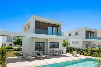 a villa with a swimming pool in front of a house at Serenity Waves Villa 17 in Larnaka