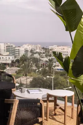 a table and chairs on a balcony with a view of a city at Shanti Tranquil Escapes in Paralimni
