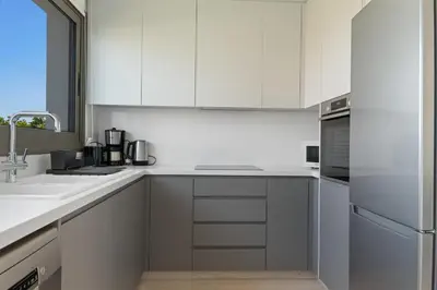 a white kitchen with a sink and a refrigerator at Serenity Waves Villa 26 in Larnaka
