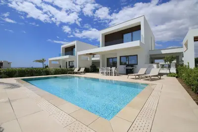 a villa with a swimming pool in front of a house at Serenity Waves Villa 27 in Sophtadhes