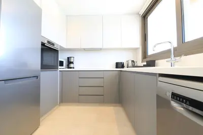a white kitchen with white cabinets and a sink at Serenity Waves Villa 27 in Sophtadhes