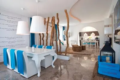 a dining room with a white table and blue chairs at Dazzling Protaras Villa Villa Akame 3 Bedrooms Beachfront in Protaras