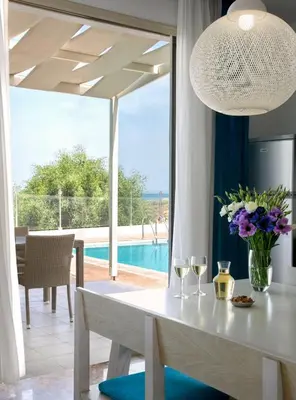 a dining room with a table with wine glasses at Exquisite Protaras Villa Villa Bulat 4 Bedrooms Beachfront in Protaras