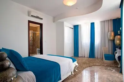 a blue and white bedroom with a bed and blue curtains at Exquisite Protaras Villa Villa Bulat 4 Bedrooms Beachfront in Protaras