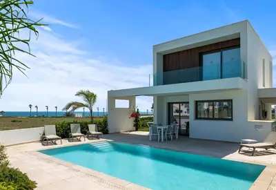 a villa with a swimming pool in front of a house at Serenity Waves Villa 22 in Larnaka