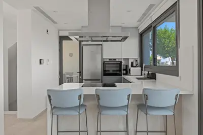a kitchen with a table and some chairs and a counter at Serenity Waves Villa 9 in Sophtadhes