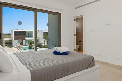 a bedroom with a bed and a large window at Serenity Waves Villa 7 in Sophtadhes